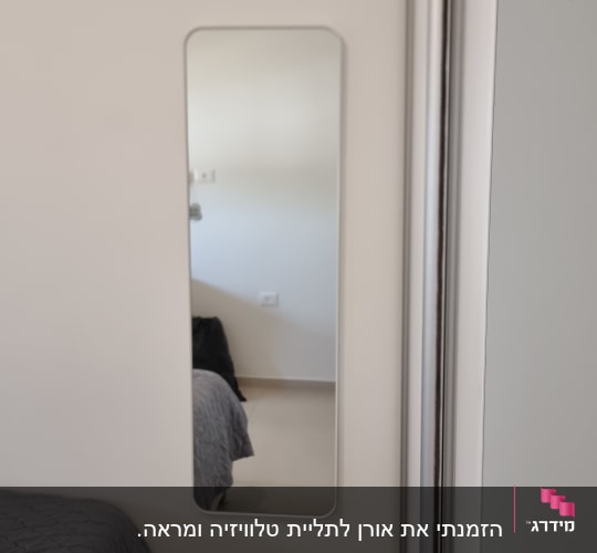 מראה מלבנית תלויה על קיר לבן